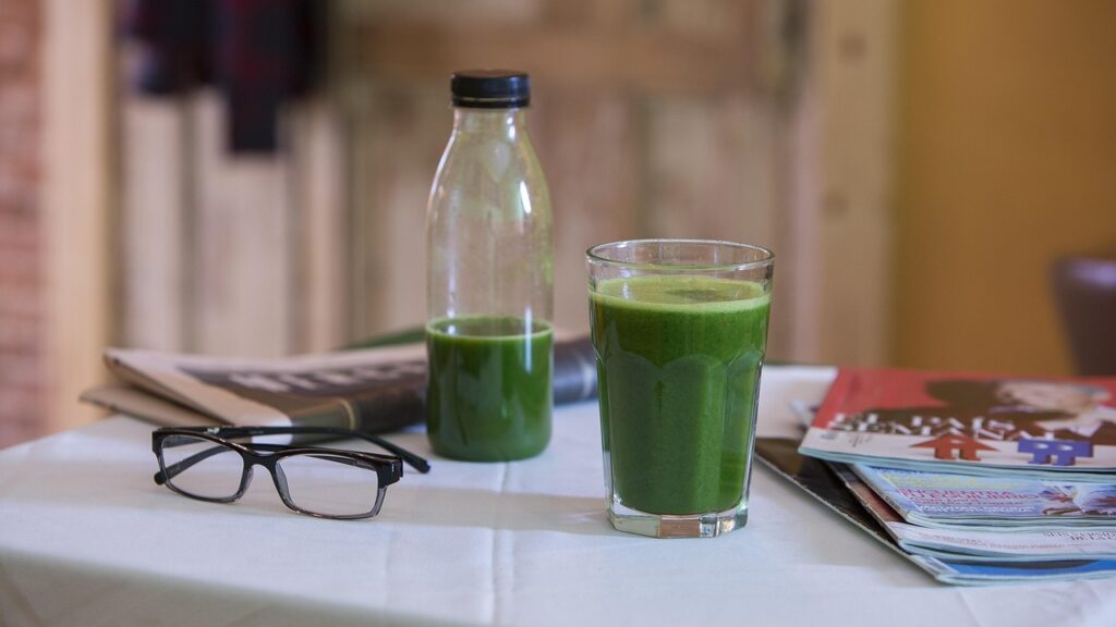 Fresh fruit, greens and juice ingredients on a kitchen table
